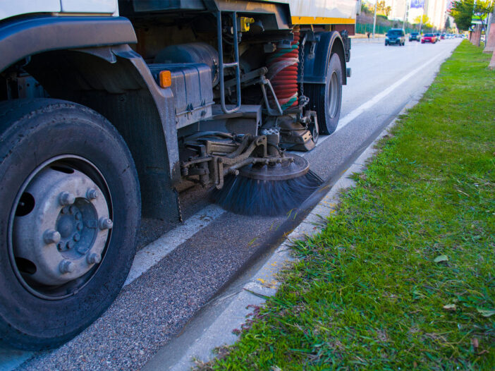 Side view of a street sweeper machine car cleaning the road