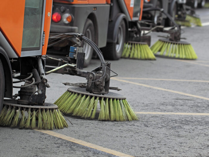 Side view of street sweepers on street